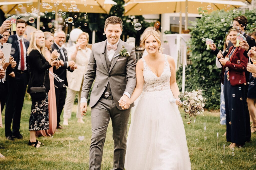 Spalier mit Seifenblasen fuer das Brautpaar bei emotionaler Hochzeit freie Trauung